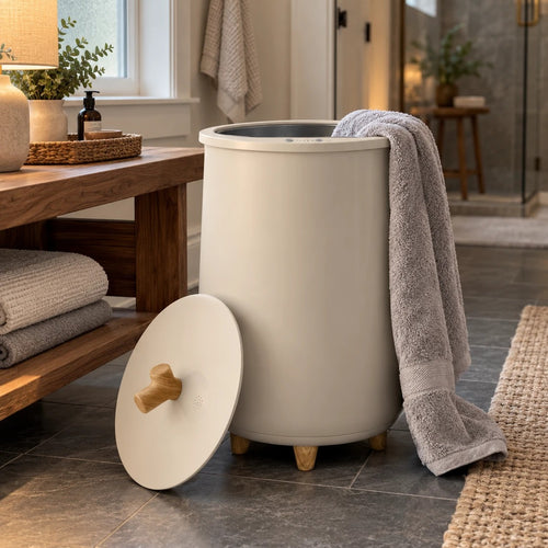 HotShift 20L towel warmer by a wooden bench in a dark bathroom before sunrise, a warm towel over the rim